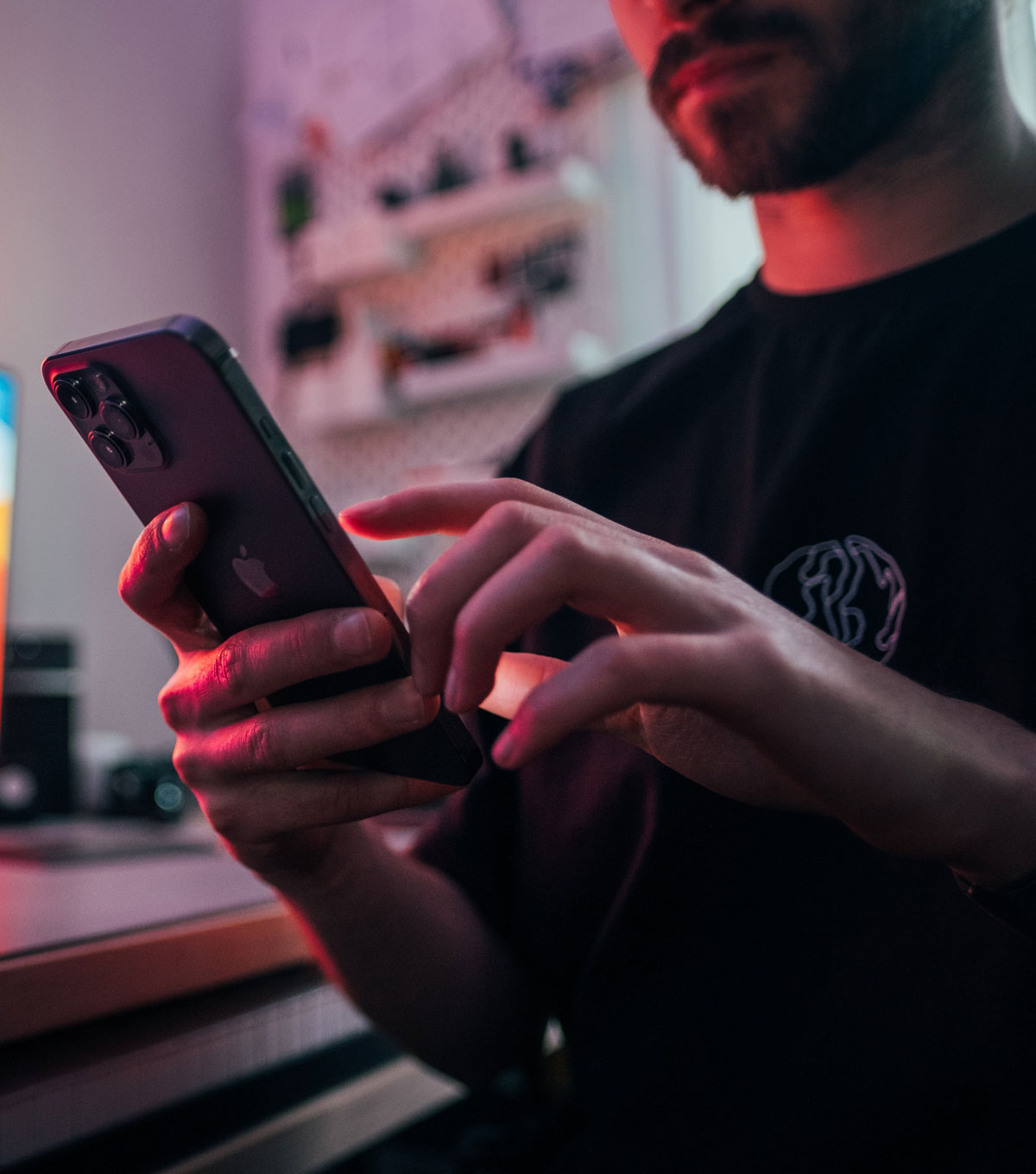 Photo of a young man holding a smartphone and tapping on the screen