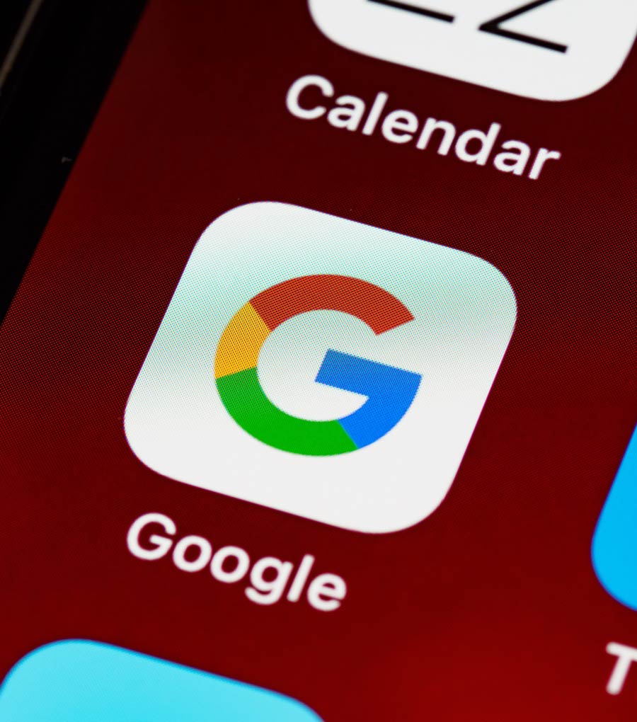 A photo of an iPhone home screen showing the Google app icon
